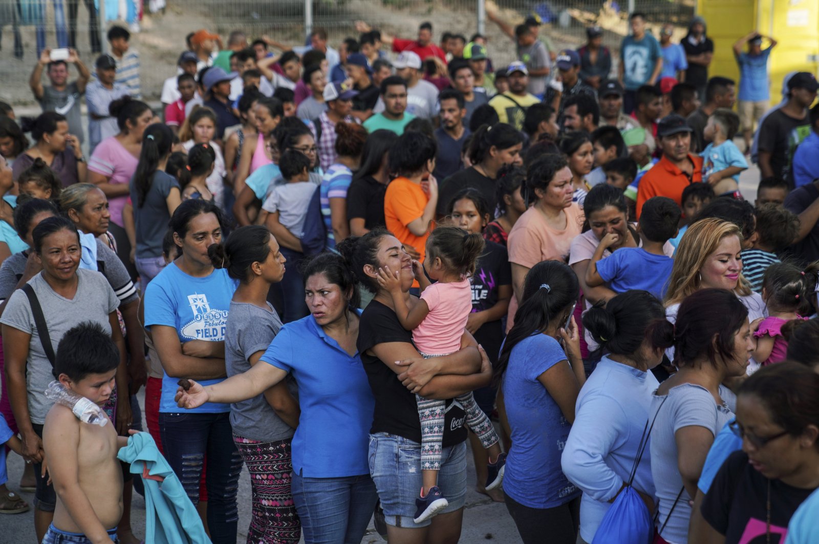 Migrants, many of whom were returned to Mexico under the Trump administration's "Remain in Mexico" policy, wait in line to get a meal in an encampment near the Gateway International Bridge in Matamoros, Mexico, Aug. 30, 2019. (AP Photo)