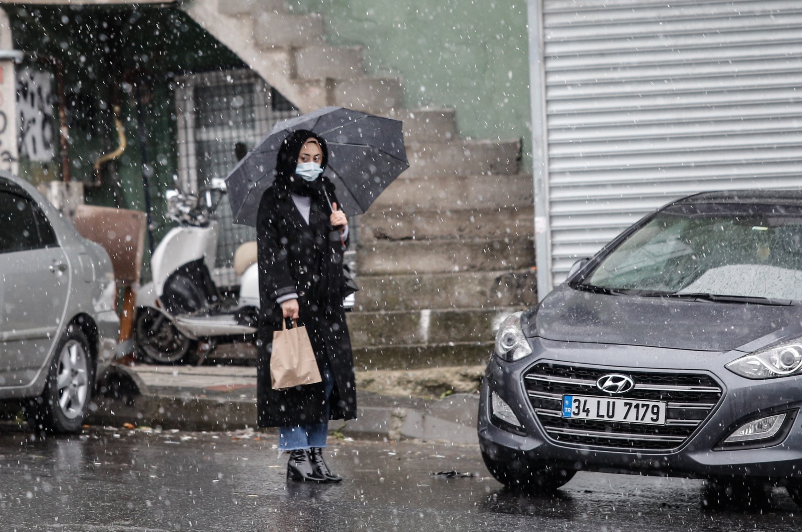 The picture shows a young woman holding an umbrella in Turkey's Istanbul on Feb. 12, 2021. (DHA Photo) 