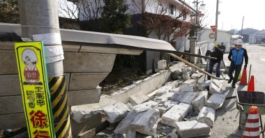Debris from a wall that collapsed during a strong earthquake covers the sidewalk in Kunimi, Fukushima Prefecture, Japan, Feb. 14, 2021. (Kyodo via Reuters)