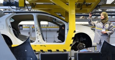 An employee of French carmaker Renault group takes a picture of a car on an assembly line during the inauguration of a new production plant, in Oued Tlelat, Oran, southern Algeria, Nov. 10, 2014. (AFP Photo)