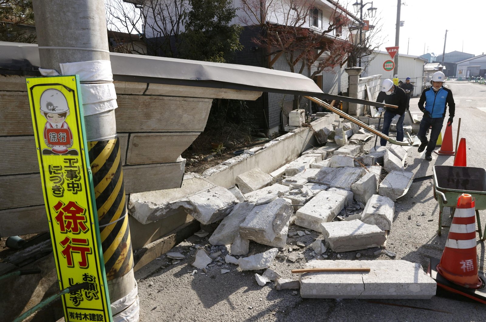 Debris from a wall that collapsed during a strong earthquake covers the sidewalk in Kunimi, Fukushima Prefecture, Japan, Feb. 14, 2021. (Kyodo via Reuters)
