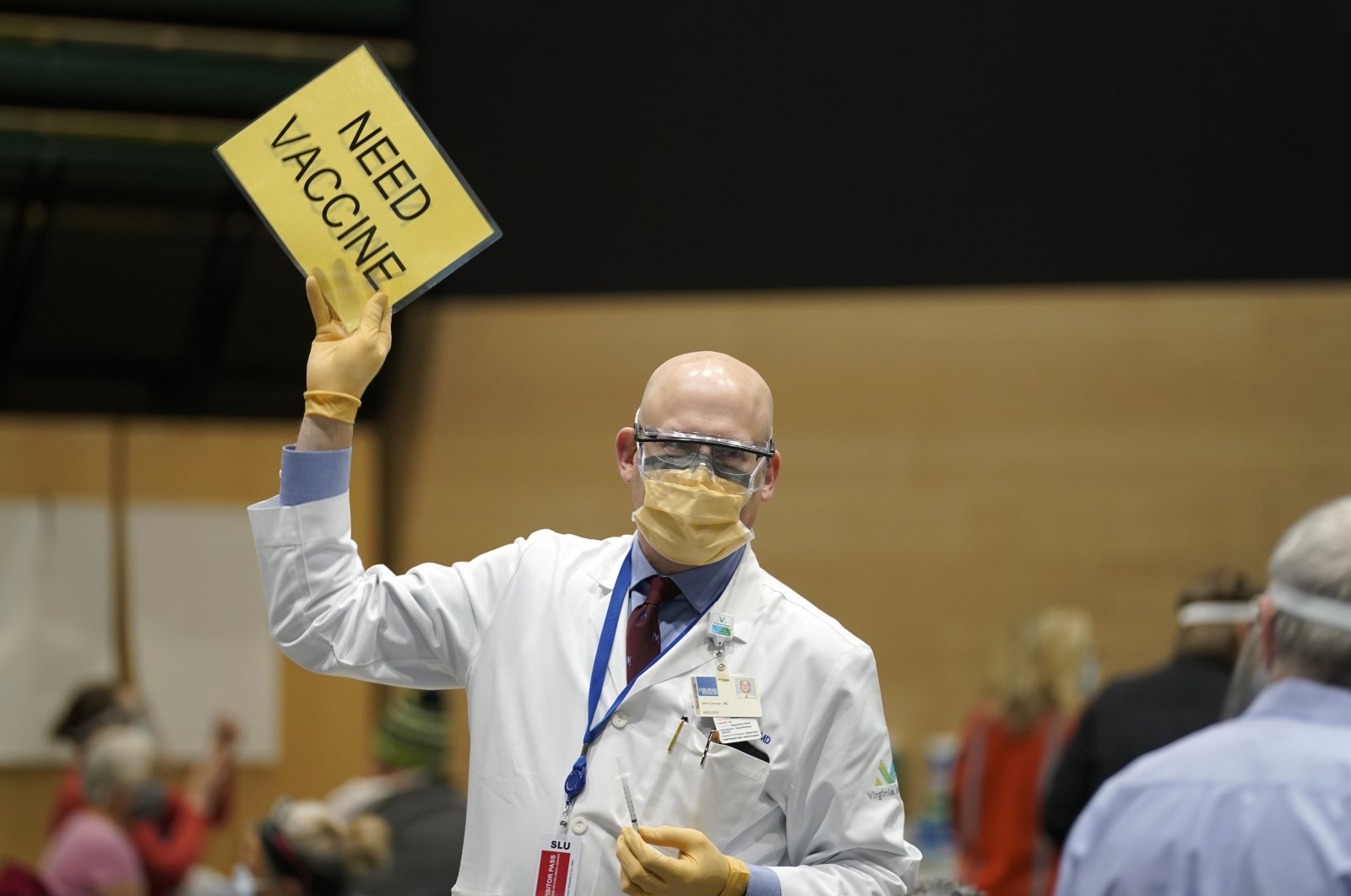 Dr. John Corman, the chief clinical officer for Virginia Mason Franciscan Health, holds a sign that reads "Need Vaccine" to signal workers to bring him more doses of the Pfizer vaccine for COVID-19 in Seattle, Washington state, U.S., Jan. 24, 2021. (AP Photo)
