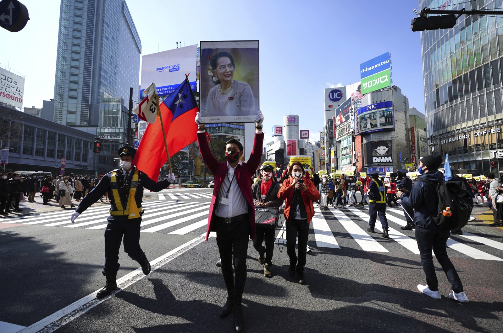 Myanmar people living in Japan and supporters march though Shibuya pedestrian crossings during a protest, Feb. 14, 2021, in Tokyo, Japan. (AP Photo)
