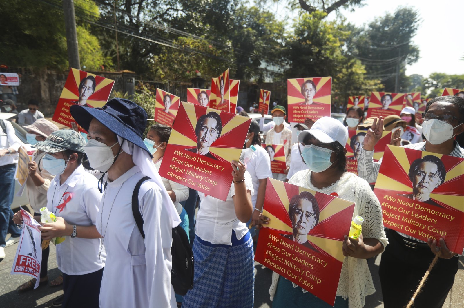 Anti-coup protesters hold posters with an image of deposed Myanmar leader Aung San Suu Kyi as they gather outside the U.N. Information Office in Yangon, Myanmar, Feb. 14, 2021. (AP Photo)