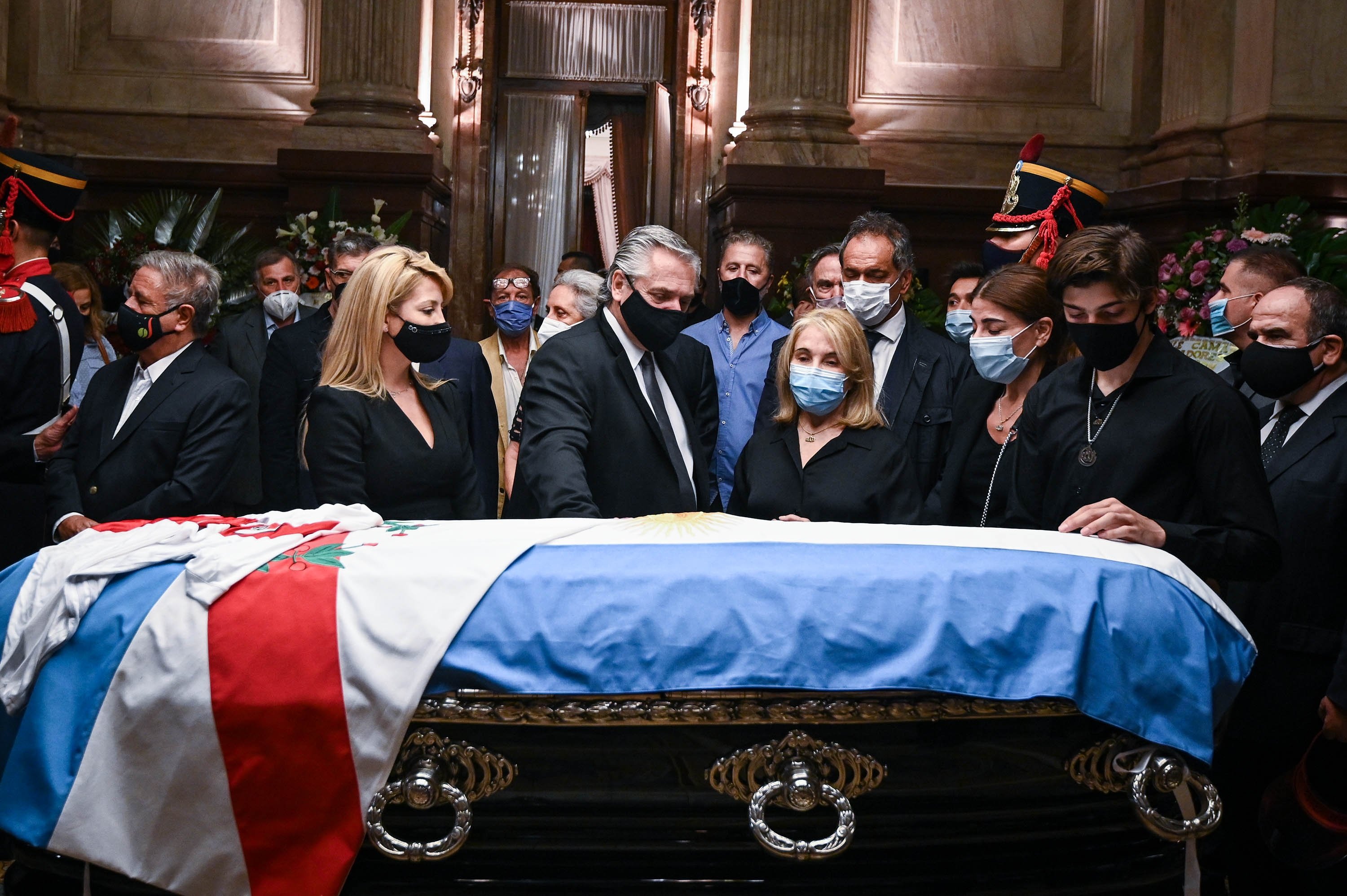 Handout picture released by the Argentine Senate showing Argentine President Alberto Fernandez (C), his partner Fabiola Yanez (2-L), Zulema Menem (3-R), her mother Zulema Yoma and his elder son Luca Bertoldi Menem standing around the coffin with the remains late former Argentine president (1989-1999) and senator Carlos Saul Menem, as he lies in state at the Congress for the wake in Buenos Aires on Feb. 14, 2021. (Photo by Charly Diaz Azcue, Argentine Senate via AFP)