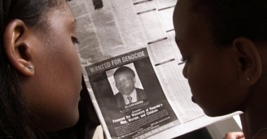 Readers look at a June 12, 2002 newspaper in Nairobi, Kenya featuring the photograph of Rwandan Felicien Kabuga wanted by the United States. (Reuters Photo)