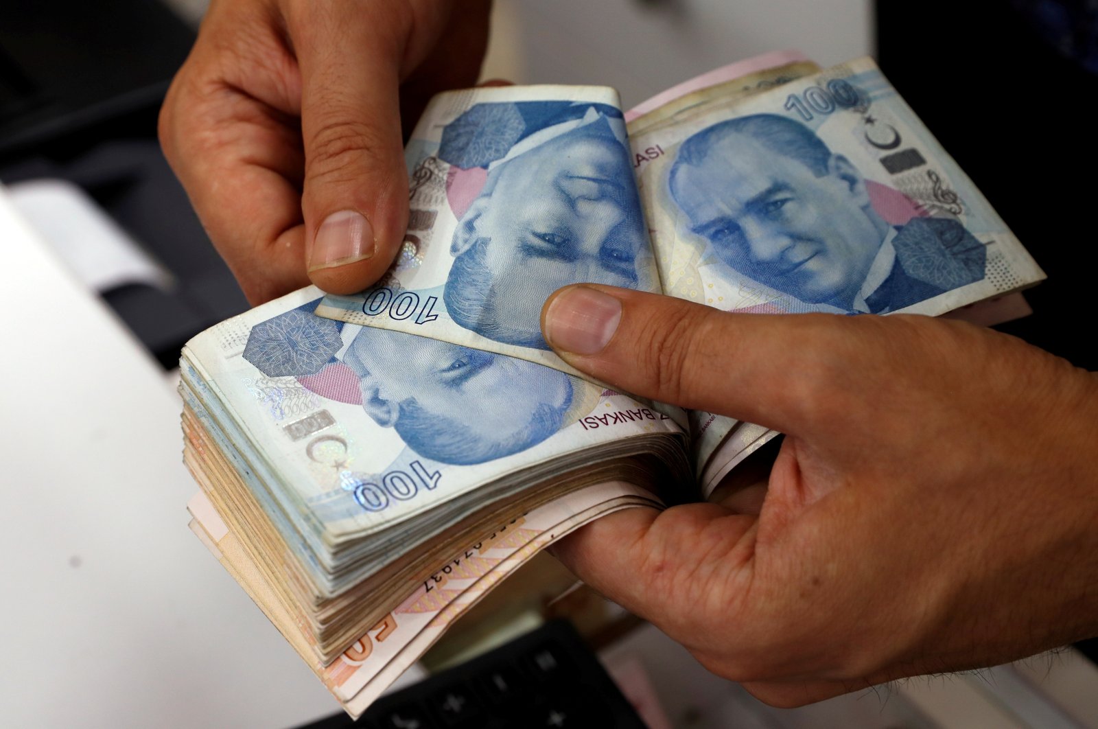 A money changer counts Turkish lira banknotes at a currency exchange office in Istanbul, Turkey, Aug. 2, 2018. (Reuters Photo)