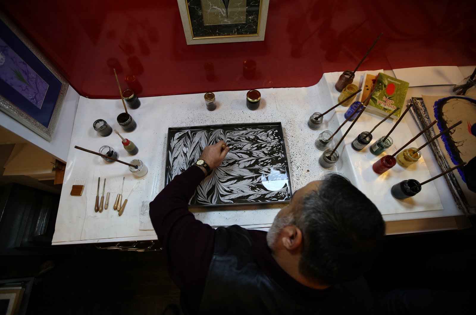 Mehmet Kotan prepares a marbling work with the powdered paint of the Oltu Stone in his workshop, Erzurum, eastern Turkey, Feb. 14, 2020. (AA PHOTO)