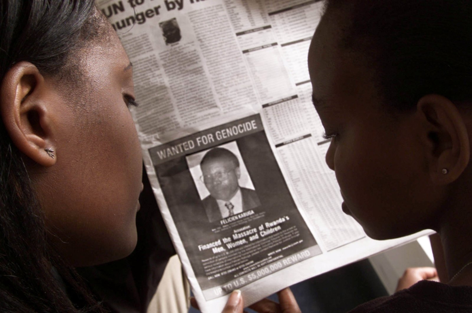 Readers look at a June 12, 2002 newspaper in Nairobi, Kenya featuring the photograph of Rwandan Felicien Kabuga wanted by the United States. (Reuters Photo)