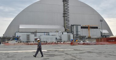 Workers walk next to the new safe confinement over the fourth block of the Chernobyl nuclear power plant, Chernobyl, Ukraine, April 26, 2017. (AFP Photo)