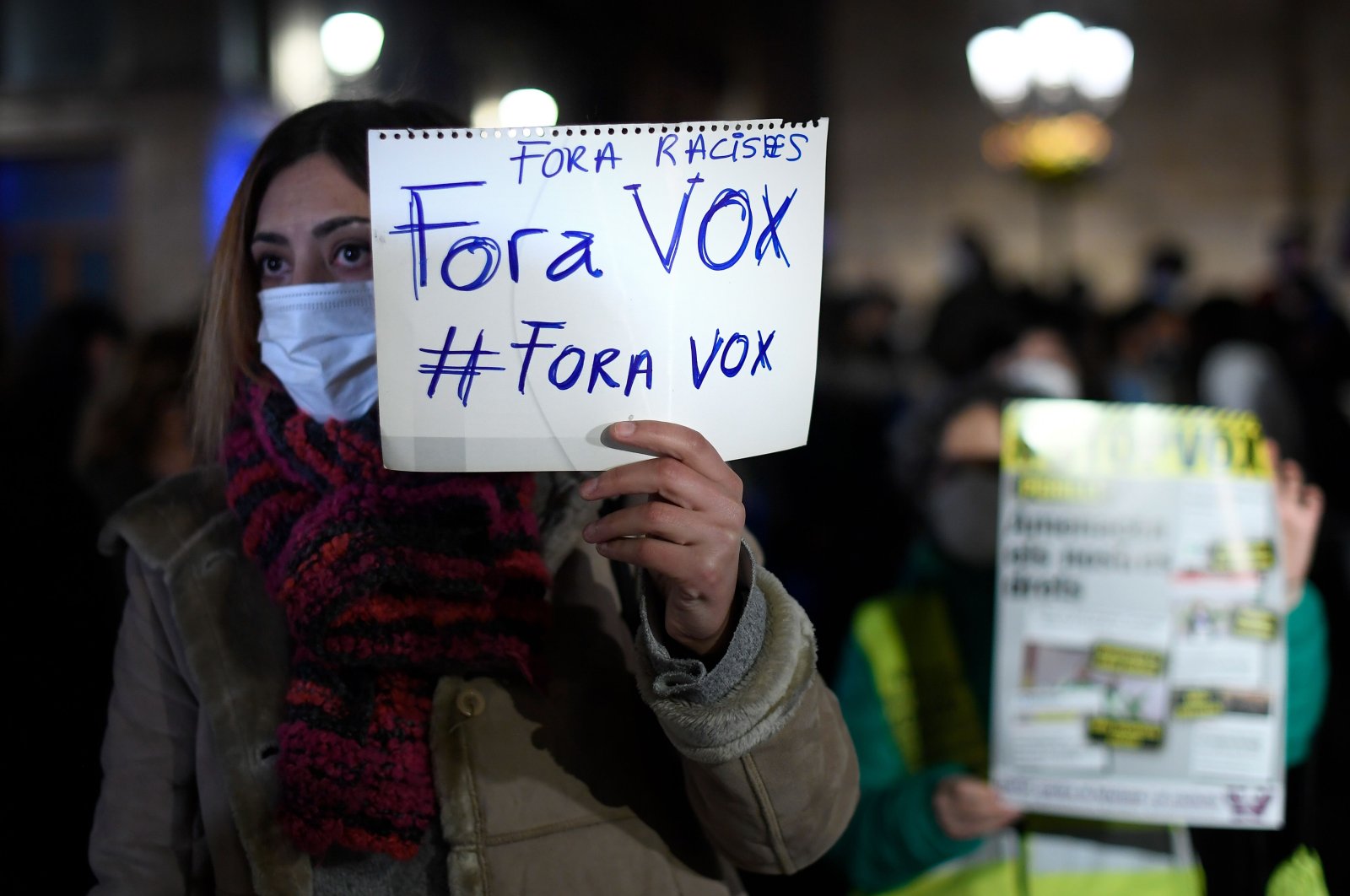 A demonstrator holds a sign reading "Vox out!" during a protest called by Unity Against Fascism and Racism (UCFR) in Barcelona, Spain on Feb. 15, 2021 (AFP Photo)