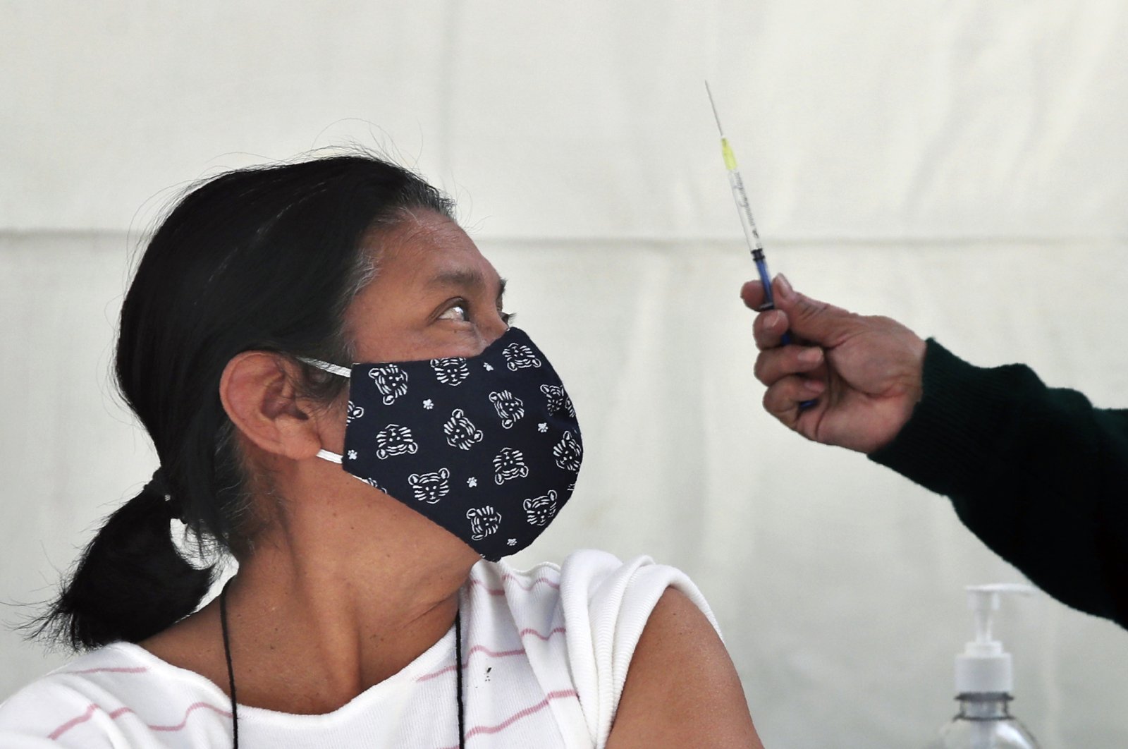 A person prepares to get a shot of the AstraZeneca vaccine against COVID-19 in the Magdalena Contreras area of Mexico City, Monday, Feb. 15, 2021, as Mexico begins to vaccinate people over age 60 against the new coronavirus. (AP Photo)
