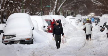 People navigate a snow-covered street in Chicago, Illinois, U.S., Feb. 16, 2021. (AFP Photo)