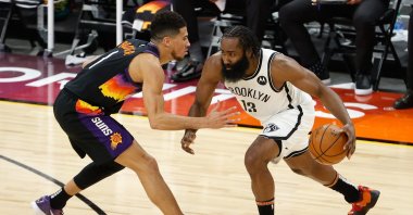 Brooklyn Nets' James Harden (R) drives the ball against Phoenix Suns' Devin Booker (L) during the second half of their NBA game at Phoenix Suns Arena, Phoenix, Arizona, Feb. 16, 2021. (AFP Photo)