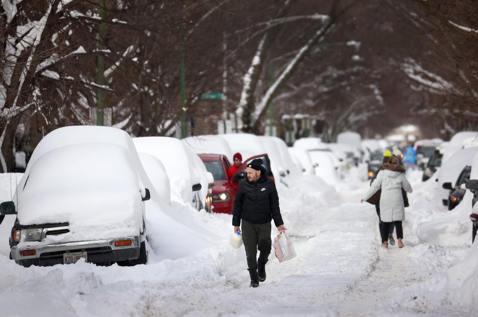 People navigate a snow-covered street in Chicago, Illinois, U.S., Feb. 16, 2021. (AFP Photo)