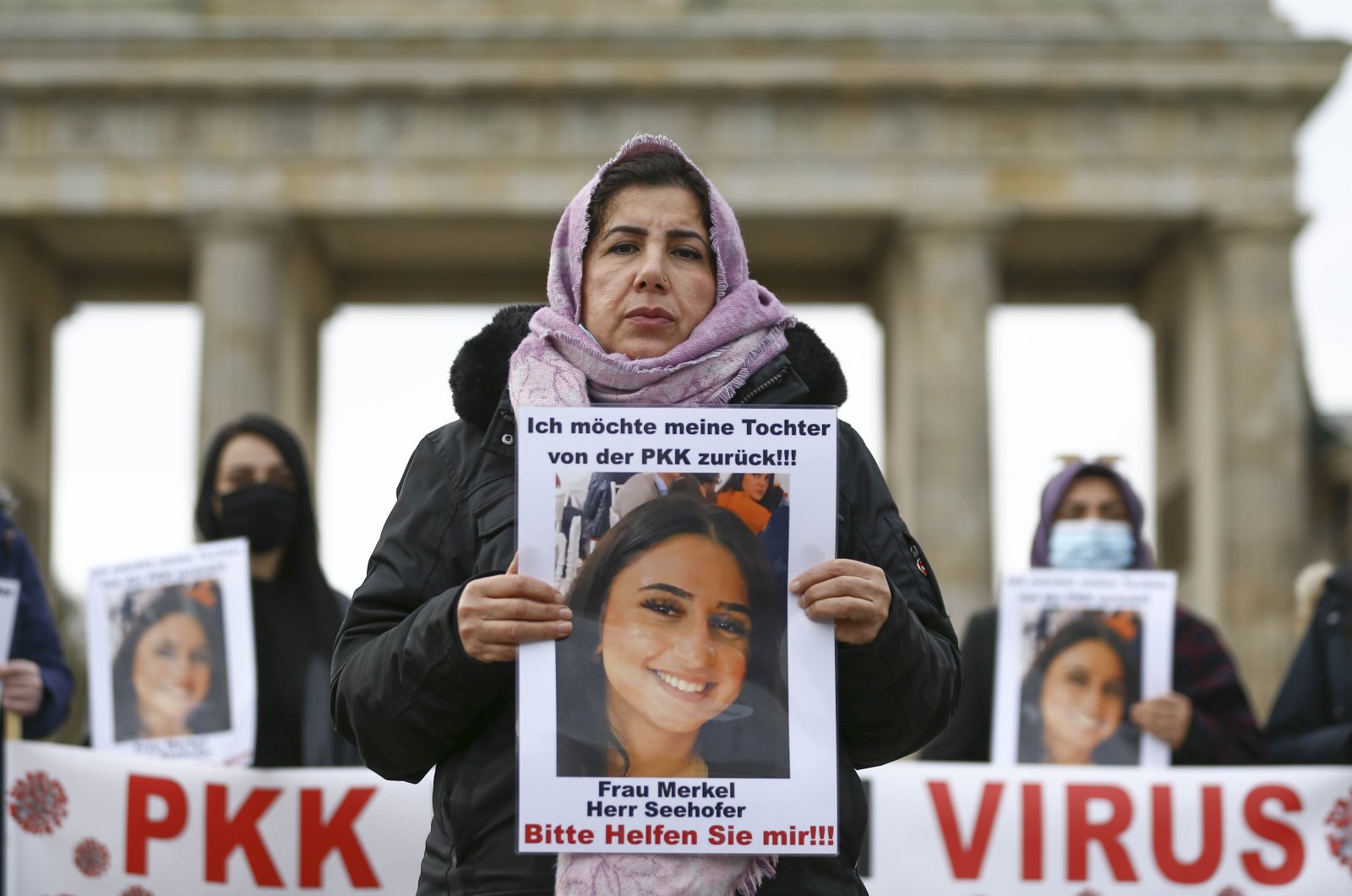 Maide T. holds a photo of her daughter, who was abducted by the PKK in a protest in front of Brandenburg Gate, Berlin, Germany, Nov. 17, 2020. (AA Photo)