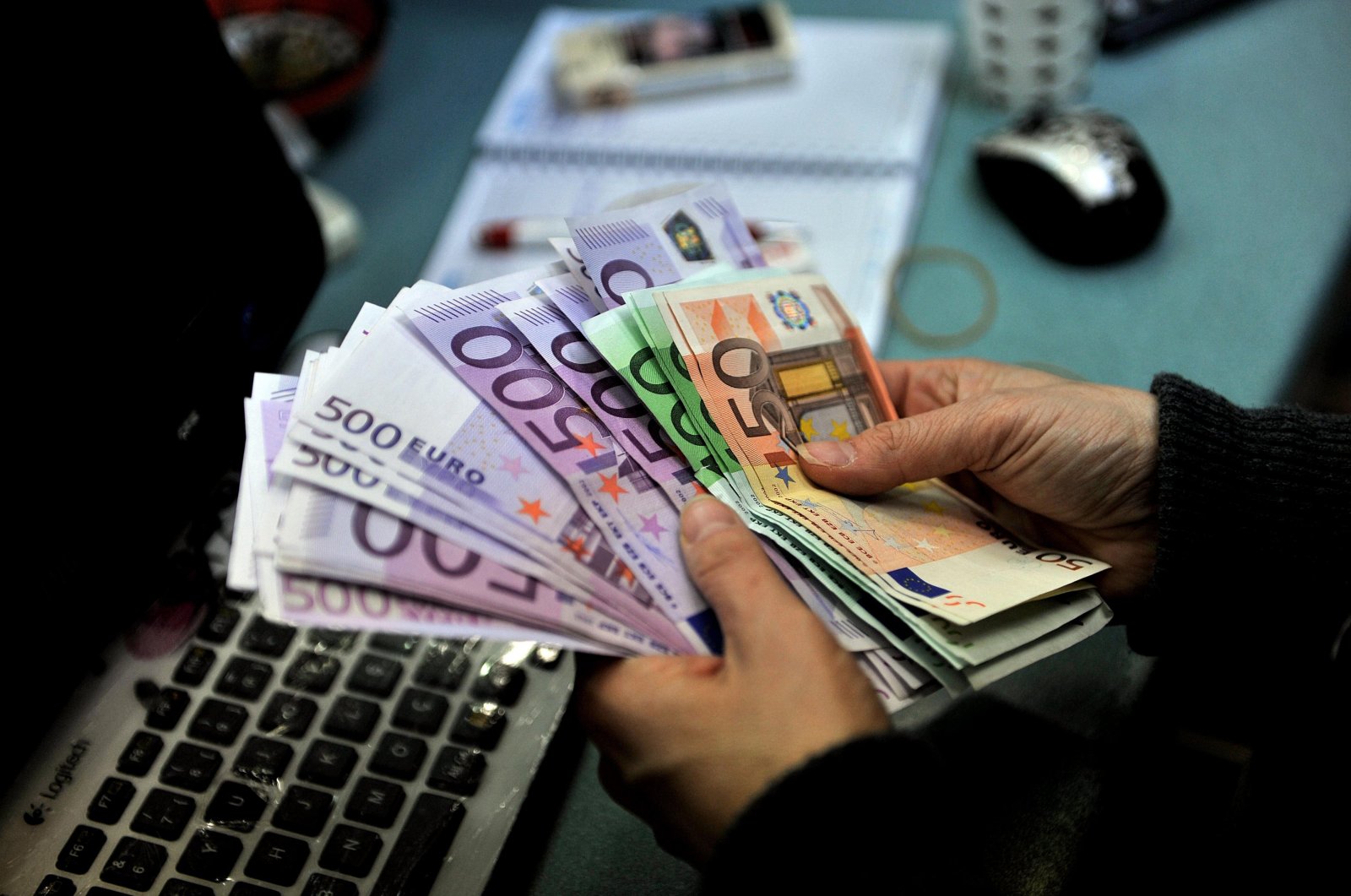 A person is seen counting money as Europe experiences a sharp rise in debt. 