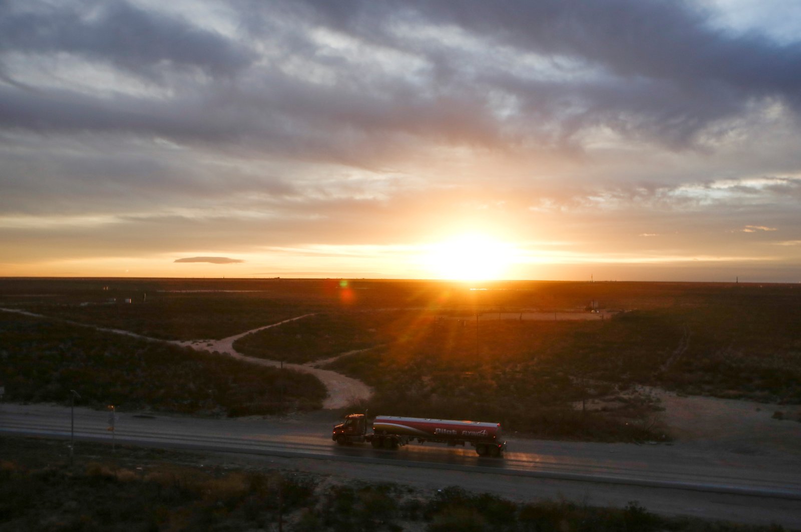 The sun rises behind an oil tanker driving through the Permian Basin in Mentone, Texas, U.S., Nov. 26, 2019. (Reuters)