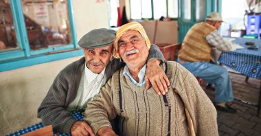 Two best friends hug each other in a traditional tea house in the Seferihisar district of Izmir, western Turkey, October 24, 2009. (Shutterstock Photo)