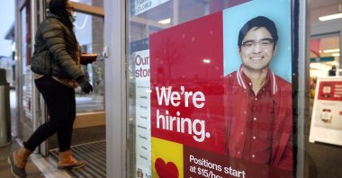 A passer-by walks past an employment hiring sign while entering a Target store location in Westwood, Mass., U.S., Feb. 9, 2021. (AP Photo)