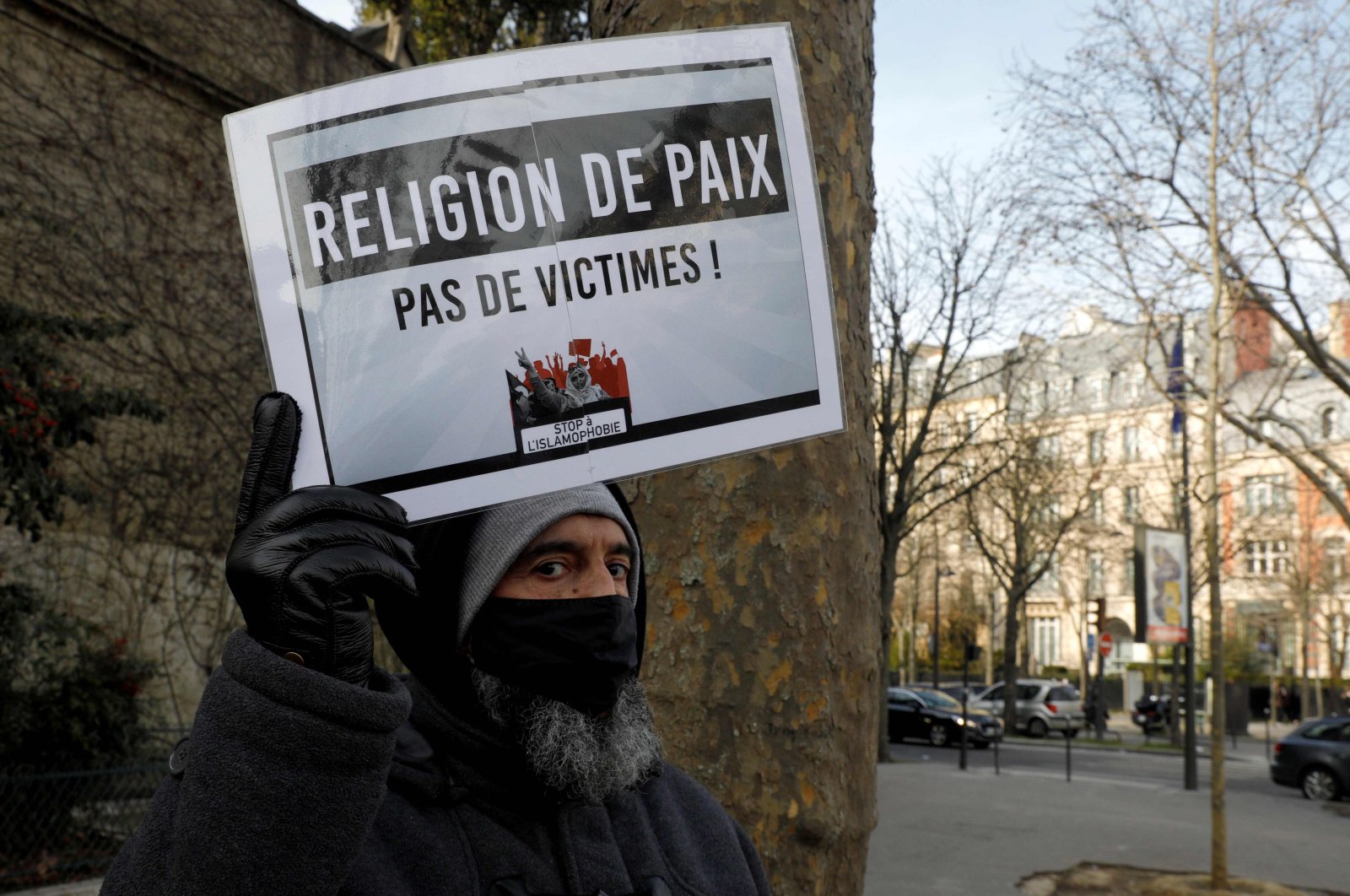 A man holds a placard reading "religion of peace" as protesters demonstrate against a bill dubbed as "anti-separatism," in Paris, France, Feb. 14, 2021. (AFP Photo)