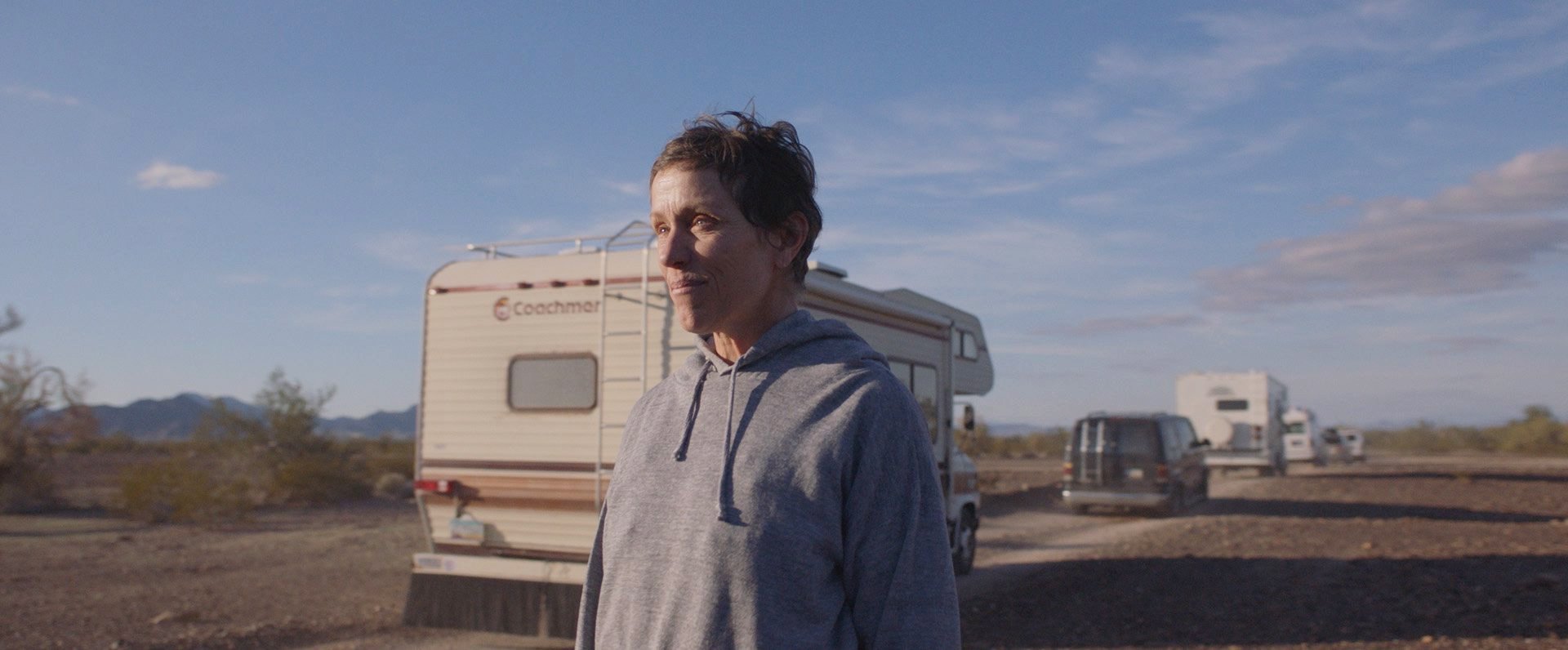 A still image from the film “Nomadland” shows Frances McDormand looking into a distance. (Searchlight Pictures via AP)