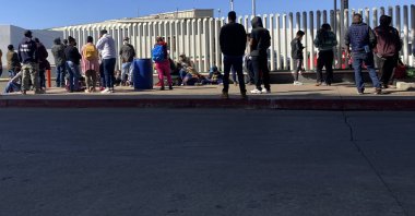 Migrants waiting to cross into the United States wait for news at the border crossing Wednesday, Feb. 17, 2021, in Tijuana, Mexico. (AP Photo)