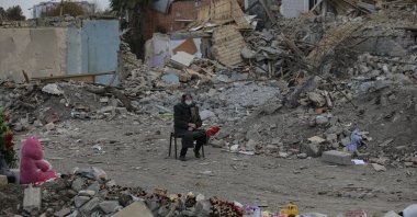 An Azerbaijani citizen sits in front of the ruins of her home, destroyed by rocket fire from Armenian forces, in Ganja, Azerbaijan, Nov. 28, 2020. (AP Photo)