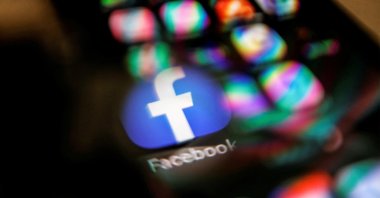 The Facebook logo displayed on a mobile phone is seen through a magnifying glass in this picture illustration taken Feb. 9, 2021. (Reuters Photo)