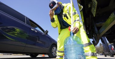 Harris County Precinct 4 employee Hector Plascencia fills containers with non-potable water at a water distribution site in Houston, Texas on Feb. 19, 2021. (AP Photo)