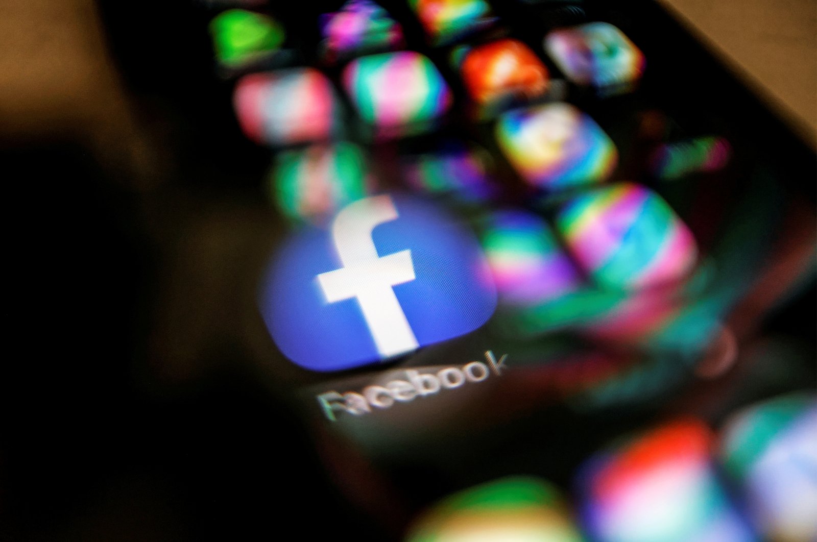 The Facebook logo displayed on a mobile phone is seen through a magnifying glass in this picture illustration taken Feb. 9, 2021. (Reuters Photo)