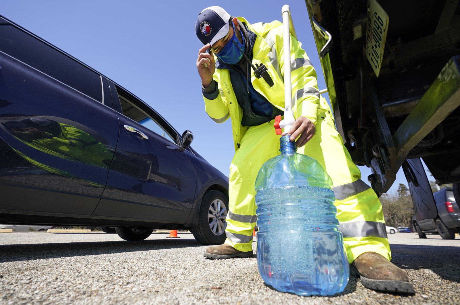 Harris County Precinct 4 employee Hector Plascencia fills containers with non-potable water at a water distribution site in Houston, Texas on Feb. 19, 2021. (AP Photo)