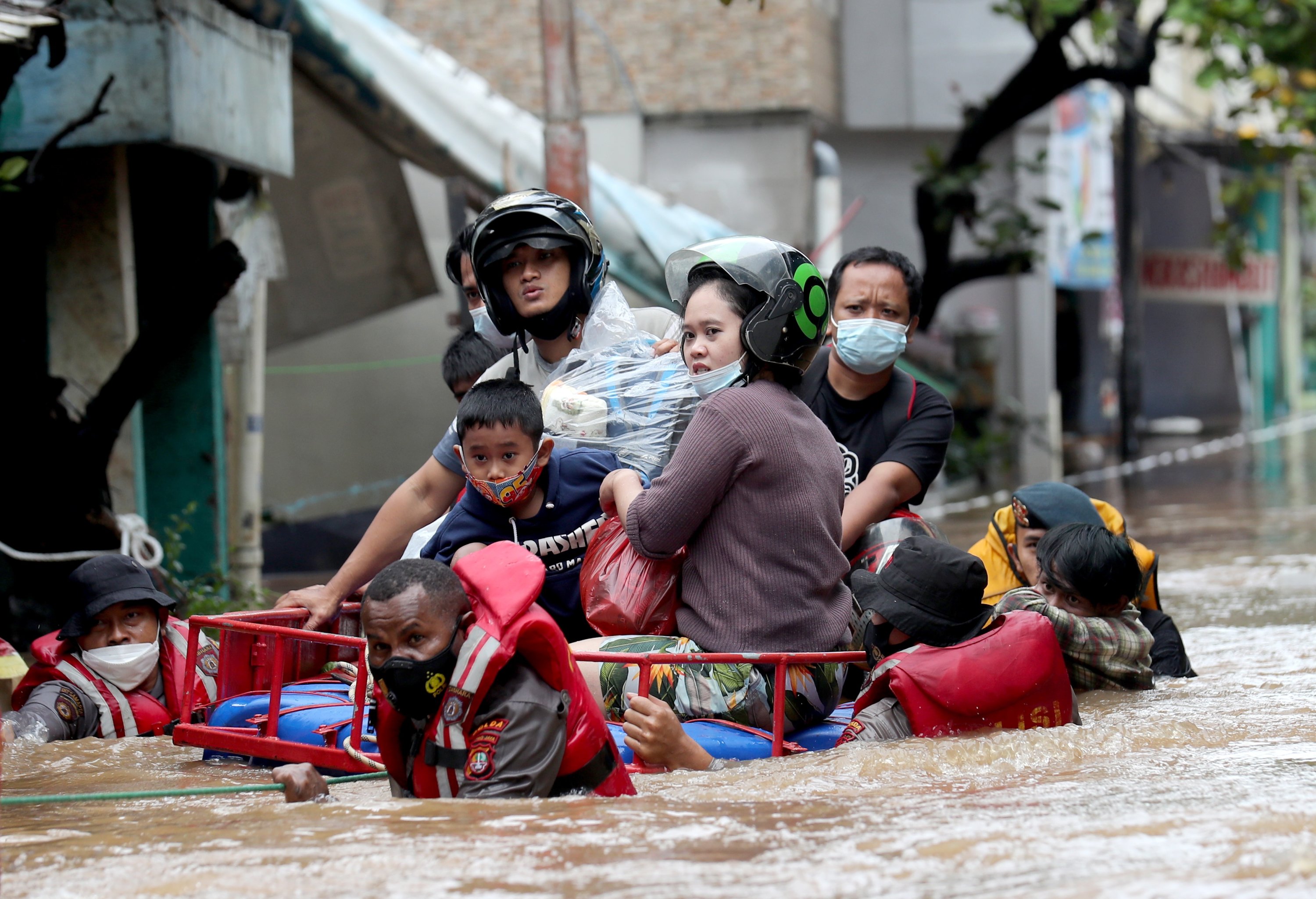 Indonesian national police wade through flood water as they rescue residents in Jakarta, Indonesia, 20 February 2021. (EPA Photo) 