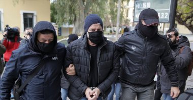 Greek actor and former director of Greece's National Theatre Dimitris Lignadis is escorted by plain clothes police officers as he enters the prosecutor's office in Athens, Greece, Feb. 21, 2021. (Reuters Photo)