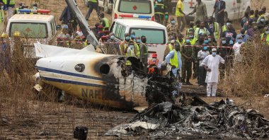 Rescuers and people gather near the debris of a Nigerian air force plane, which according to the aviation minister crashed while approaching the Abuja airport runway, in Abuja, Nigeria, Feb. 21, 2021. (Reuters Photo)