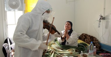 Dr. Mohamed Salah Siala plays the violin for patients on the COVID wards of the Hedi Chaker hospital in Sfax, eastern Tunisia, Feb. 20, 2021.  (AP Photo)