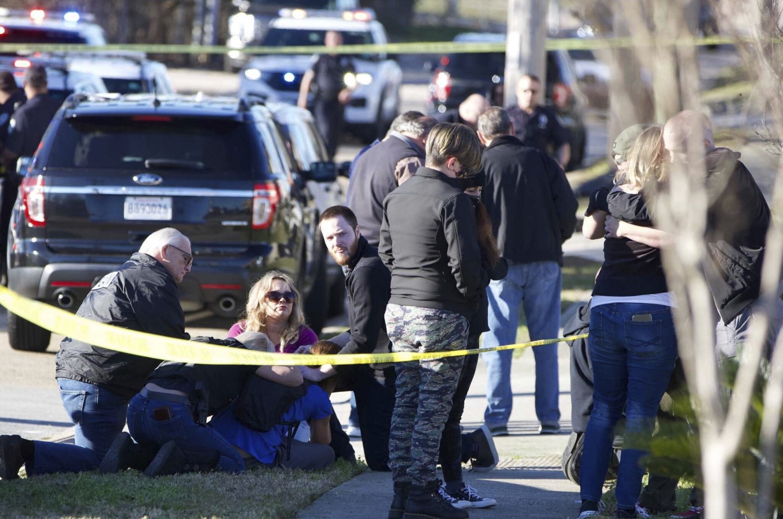 People are comforted by law enforcement as the Jefferson Parish Sheriff's Office deputies investigate a shooting at the Jefferson Gun Outlet in Metairie, Louisiana, U.S., Feb. 20, 2021. (AP Photo)