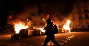 A barricade built with trash containers burns during a protest in support of Catalan rapper Pablo Hasel, after he was given a jail sentence on charges of glorifying terrorism and insulting royalty in his songs, in Barcelona, Spain, Feb. 19, 2021. (Reuters Photo)