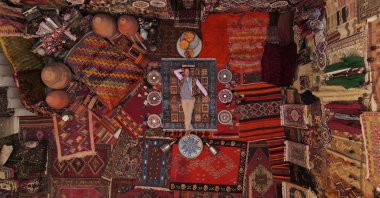 Richard Quest of CNN's "Quest's World of Wonder" lays among Turkish carpets at Cappadocia. (Courtesy of Warner Media)