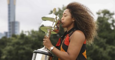 Japan's Naomi Osaka kisses the Daphne Akhurst Memorial Cup during a photo shoot after defeating U.S.' Jennifer Brady in the Australian Open women's singles final in Melbourne, Australia, Sunday, Feb. 21, 2021. (AP Photo)