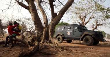 Children are seen sitting on a tree trunk next to an armored personnel carrier stationed inside the Government Science College where gunmen kidnapped dozens of students and staff members, in Kagara, Rafi Local Government Niger State, Nigeria, Feb. 18, 2021 (AFP Photo)