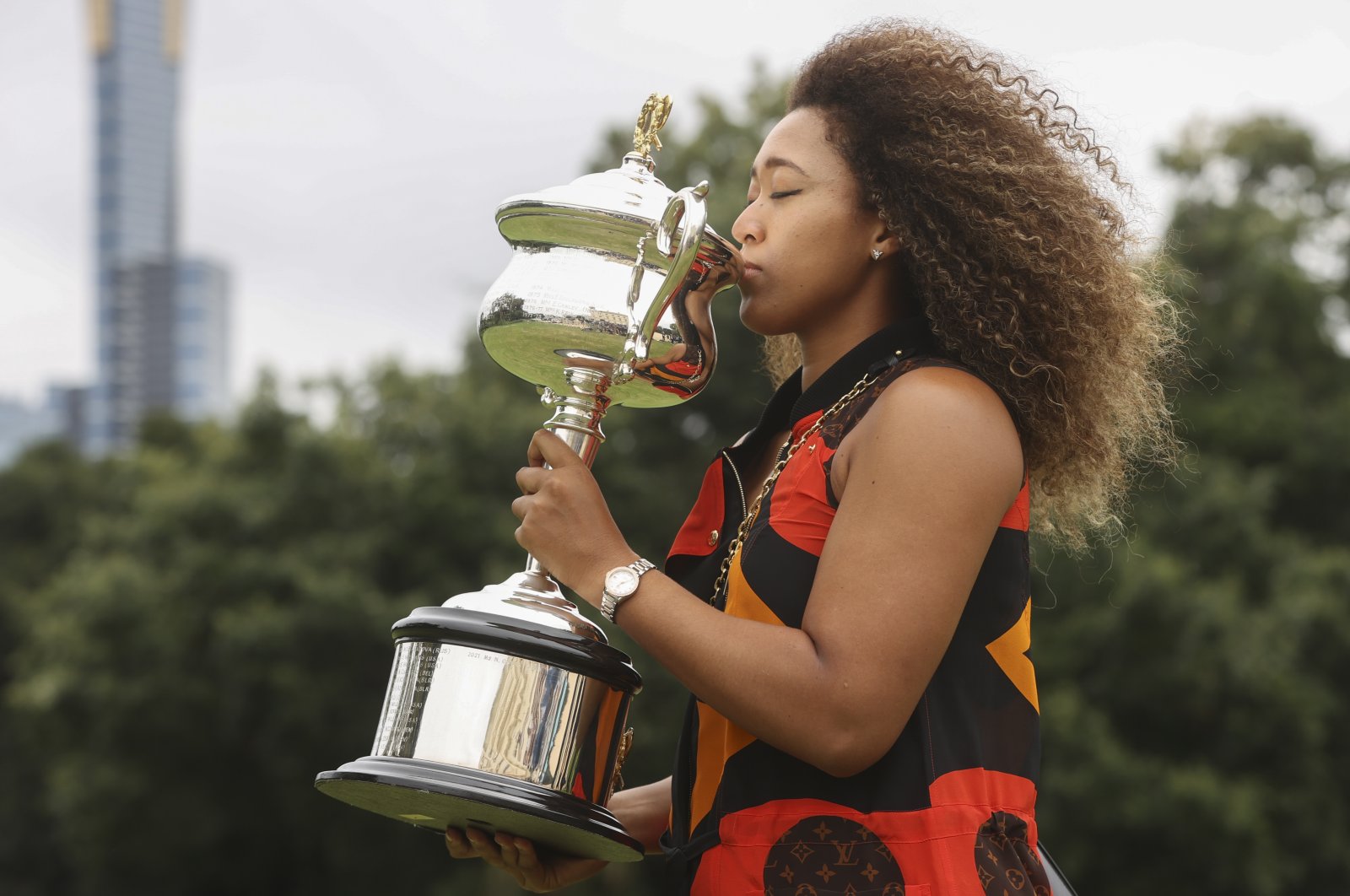 Japan's Naomi Osaka kisses the Daphne Akhurst Memorial Cup during a photo shoot after defeating U.S.' Jennifer Brady in the Australian Open women's singles final in Melbourne, Australia, Sunday, Feb. 21, 2021. (AP Photo)