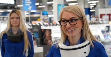 Euronics shop customer service employees Anita Kangro and Katrin Veltson use wearable UV air purifiers to protect against viruses in Tallinn, Estonia, Feb. 22, 2021. (Reuters Photo)