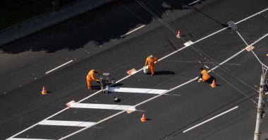Road workers paint white lines on the road during road construction, Kyiv, Ukraine, May 25, 2020. (Shutterstock Photo)