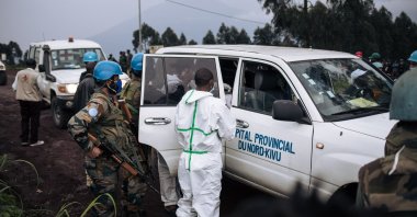 The body of a driver, who was killed in an attack, is loaded on to a medical vehicle on a road on the edge of the Virunga National Park near the village of Kibumba, some 25 kilometers from Goma, Democratic Republic of the Congo, Feb. 22, 2021. 