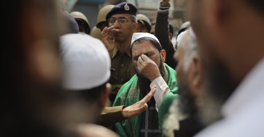 A man gestures as a senior Delhi police officer speaks to a group of Muslims ahead of Friday prayers near a heavily policed, fire-bombed mosque in New Delhi, India, Feb. 28, 2020. (AP Photo)