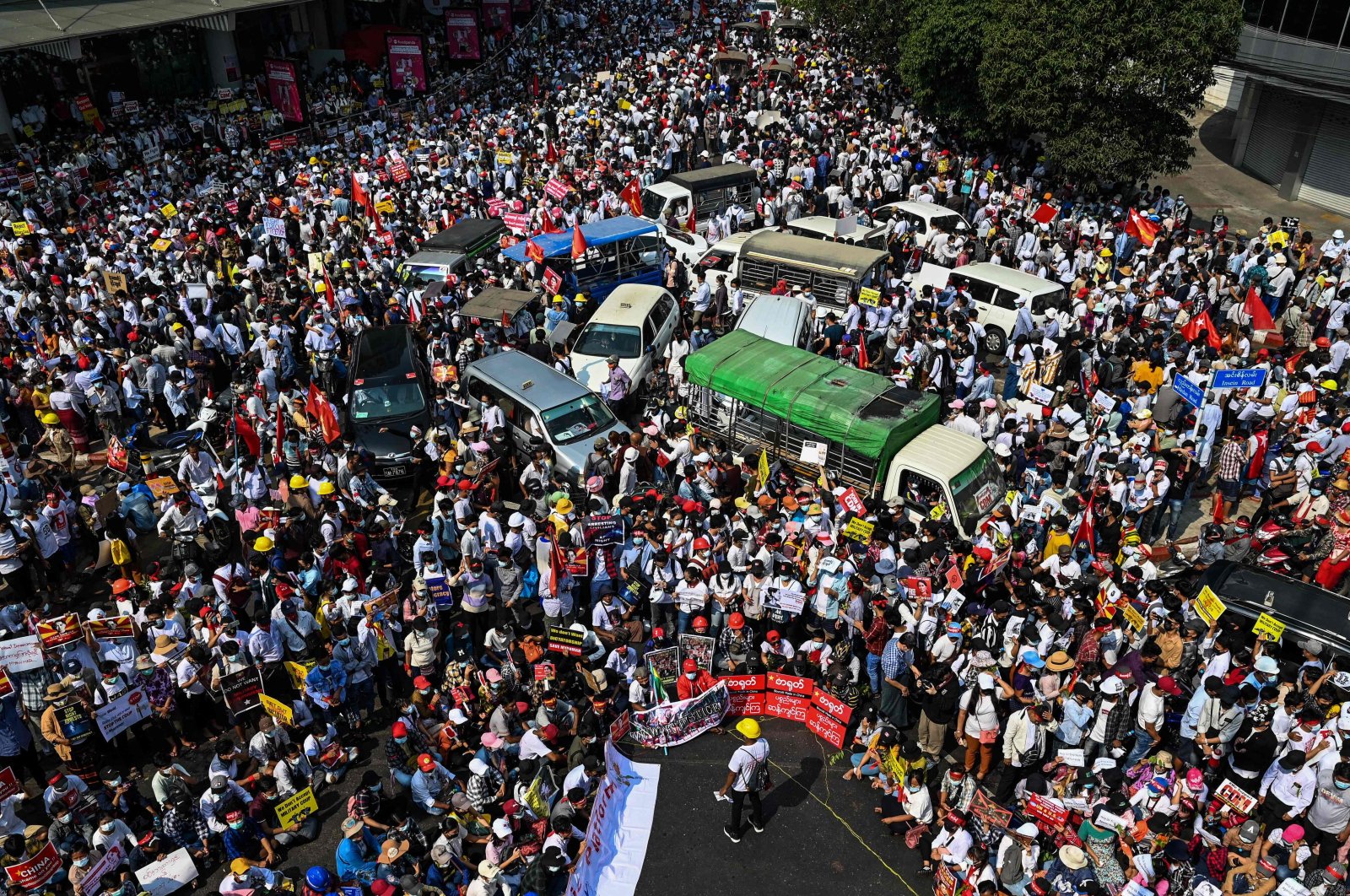 Protesters mass around vehicles as they block roads during a demonstration against the military coup in Yangon on Feb. 22, 2021. (AFP Photo)