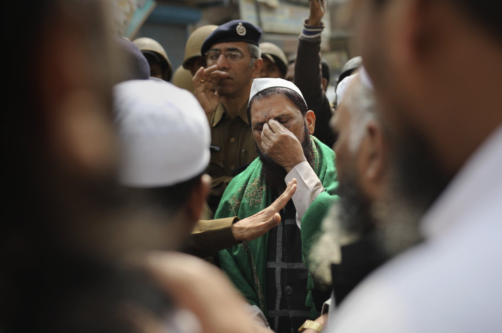 A man gestures as a senior Delhi police officer speaks to a group of Muslims ahead of Friday prayers near a heavily policed, fire-bombed mosque in New Delhi, India, Feb. 28, 2020. (AP Photo)