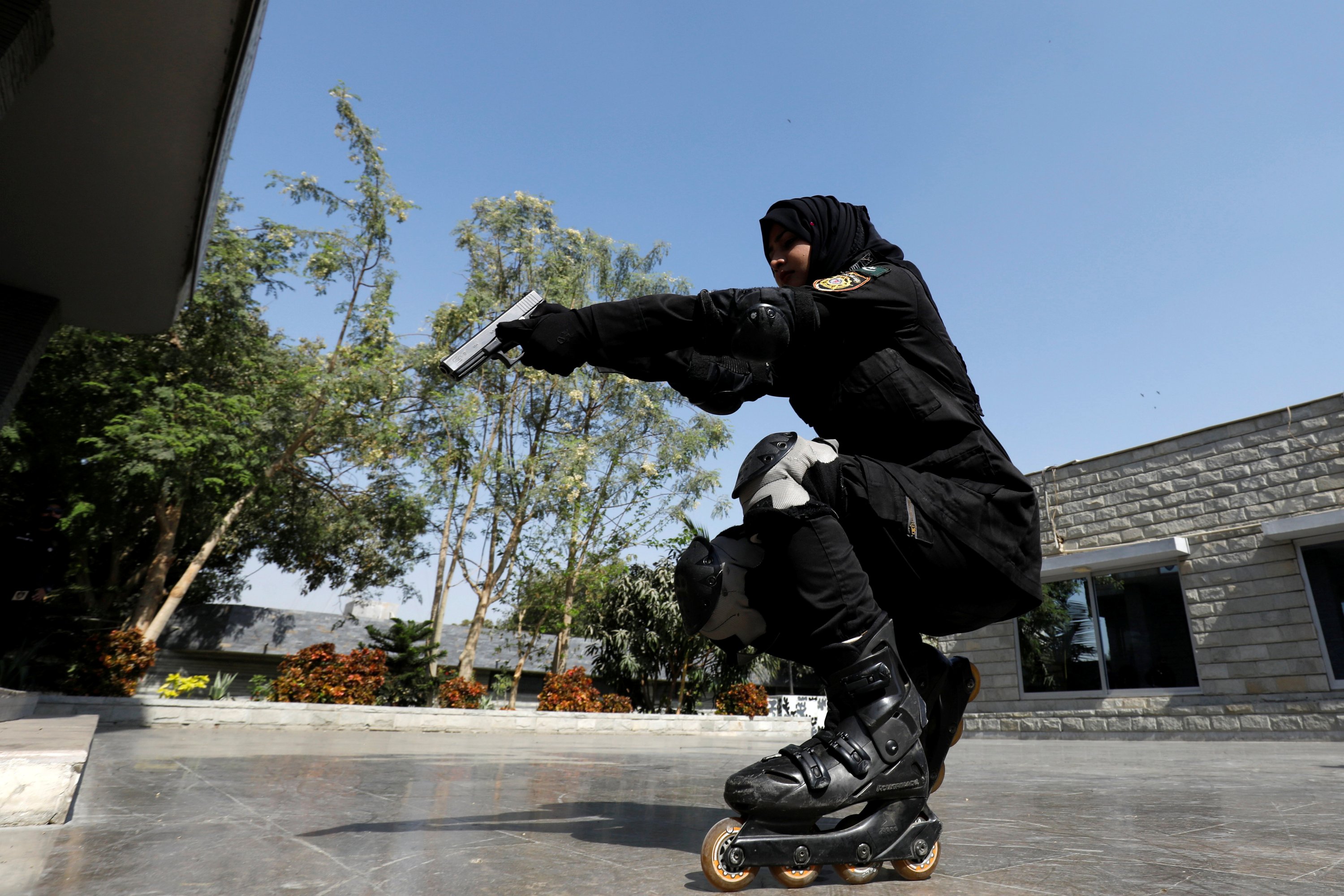 A Special Security Unit (SSU) police member holds up her weapon as she rollerblades during practice at the headquarters in Karachi, Pakistan, Feb. 18, 2021. (Reuters Photo)