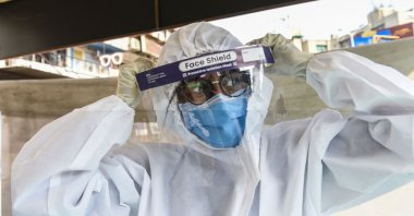 A health worker wears a Personal Protective Equipment (PPE) suit before collecting swab samples from people to test for the coronavirus, Ahmedabad, India, Feb. 22, 2021. (AFP Photo)